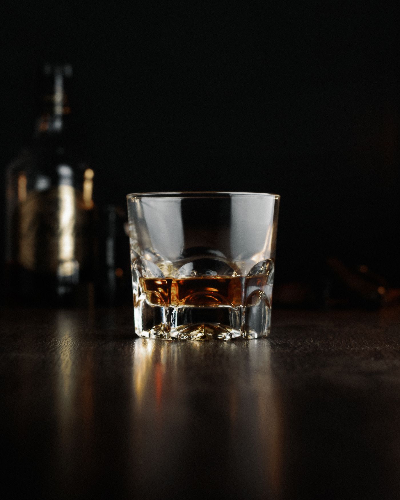 Whisky in proefglazen met flessen op de achtergrond